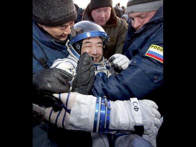 Ground personnel help member of the ISS crew Japanese astronaut Satoshi Furukawa to get out off the Soyuz capsule minutes after landing near the town of Arkalyk, northern Kazakhstan. AP Photo/Sergei Remizov