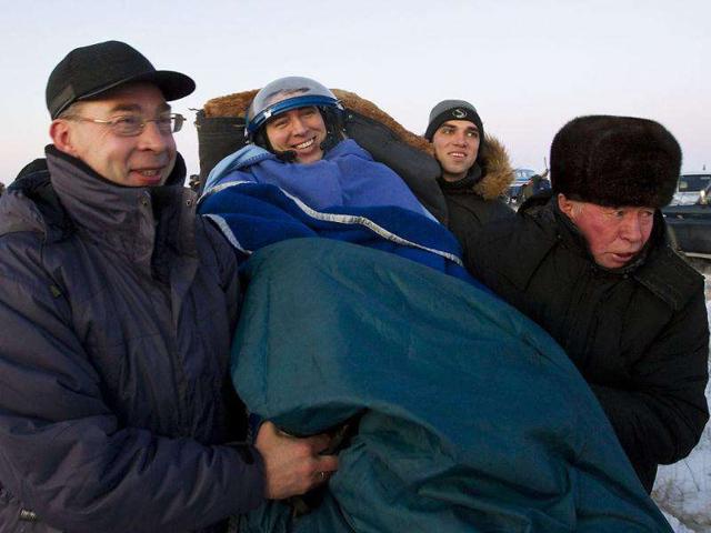 Ground personnel carry ISS crew member and Russian cosmonaut Sergei Volkov after landing in a Soyuz capsule near the town of Arkalyk, northern Kazakhstan. AP Photo/Shamil Zhumatov
