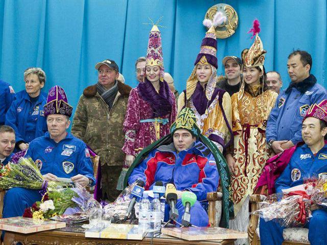 Wearing Kazakh traditional costumes three astronauts, (L-R) American Mike Fossum, Russia's Sergei Volkov and Japan's Satoshi Furukawa, attend their press conference in Kostanay some hours after their landing in Soyuz TMA-02 capsule near the in northern Kazakhstan. AFP PHOTO / Shamil Zhumatov