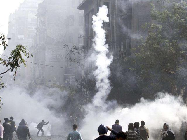 Protesters run from tear gas fired by riot police during clashes along a road which leads to the interior ministry, near Tahrir Square in Cairo. Photo: Reuters/Mohamed Abd El-Ghany