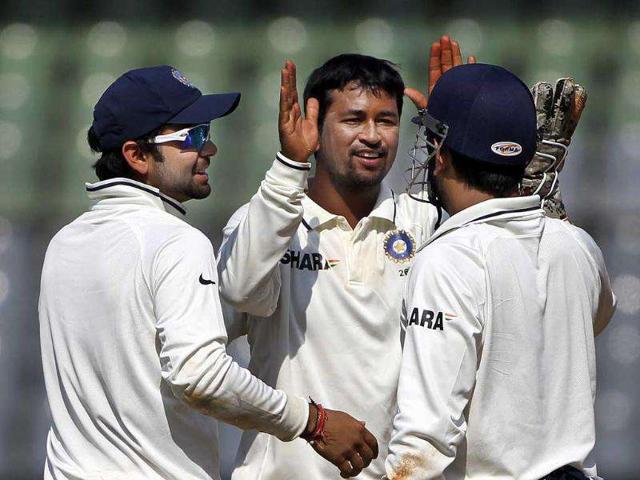 Indian cricketers from left, Virat Kohli, Pragyan Ojha and captain Mahendra Singh Dhoni celebrate the wicket of West Indies batsman, Kieren Powell during the second day of the third test cricket match in Mumbai.