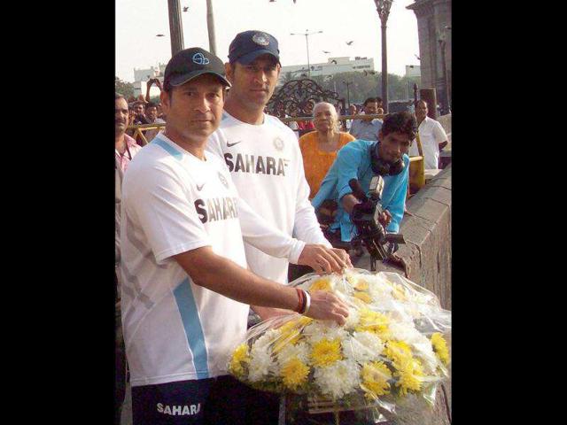 Sachin Tendulkar and Mahendra Singh Dhoni pays tribute to the victims of 26/11 Mumbai terror attacks in Mumbai before boarding the team bus for the fifth day of the third Test against West Indies.