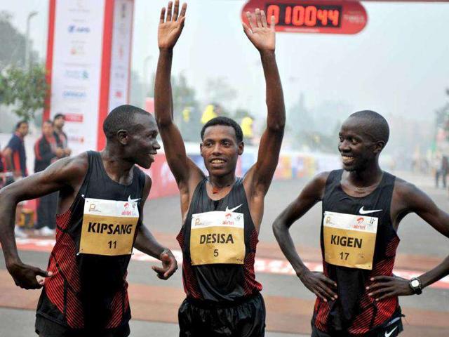 Geoffrey Kipsang of Kenya, Lelisa Desisa of Ethiopia and Mike Kigen of Kenya gesture after crossing the finishing line of the Airtel Delhi Half Marathon 2011 in New Delhi.