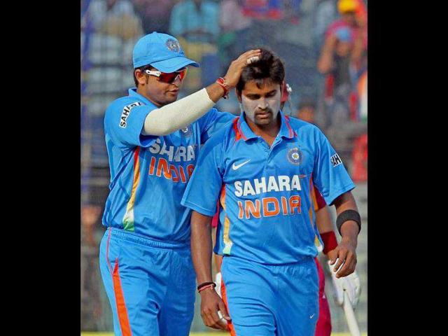 Vinay Kumar in encouraged by Suresh Raina as he prepares to bowl against West Indies during their 1st ODI cricket match in Cuttack.