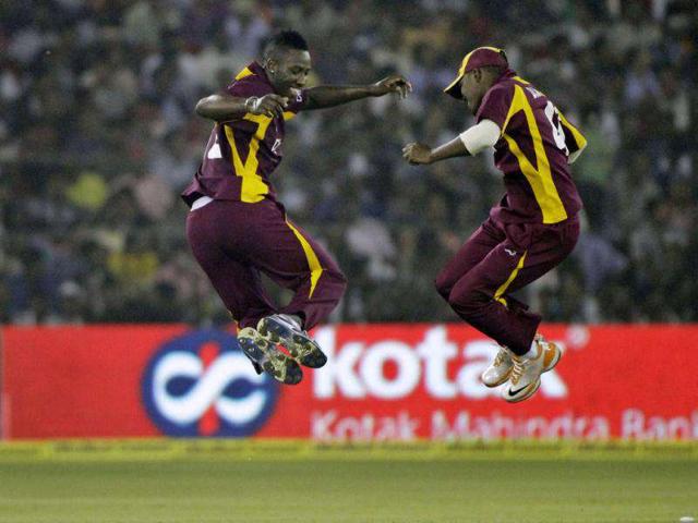 West Indies' Andre Russell (L) and Darren Bravo celebrate the dismissal of India's captain Virender Sehwag (unseen) during the first ODI cricket match in Cuttack. AP