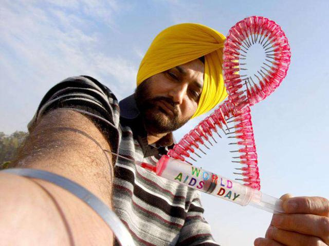 Harwinder Singh Gill a city artist displays his creation as a visual message to spread awareness on the eve of World Aids Day in Amritsar. Munish Byala/HT