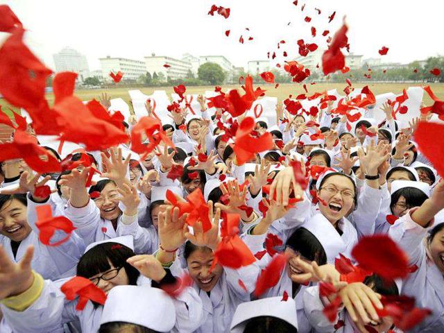 Nurses throw rose petals and red ribbons to mark World AIDS Day at a medical school in Yangzhou, Jiangsu province.