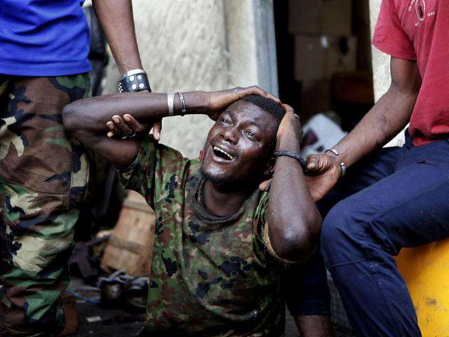 A prisoner held by pro-Outtara Republican Forces of Ivory Coast (FRCI) and who said he was shot in the leg during recent fighting, badly beaten and held in a dark cell for days, weeps in pain at a military base in Ivory Coast's main city Abidjan, in this file photo. The International Criminal Court confirmed former Ivory Coast President Laurent Gbagbo had been detained in The Hague on November 30, 2011, following his arrest on charges of crimes against humanity and transfer from Ivory Coast overnight. (Reuters)