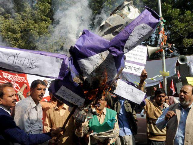 Activists from the CPI-ML shout anti-government slogans as they burn an effigy of Prime Minister Manmohan Singh during a protest against the government's decision to allow 51% Foreign Direct Investment (FDI) in multi-brand retail in New Delhi.