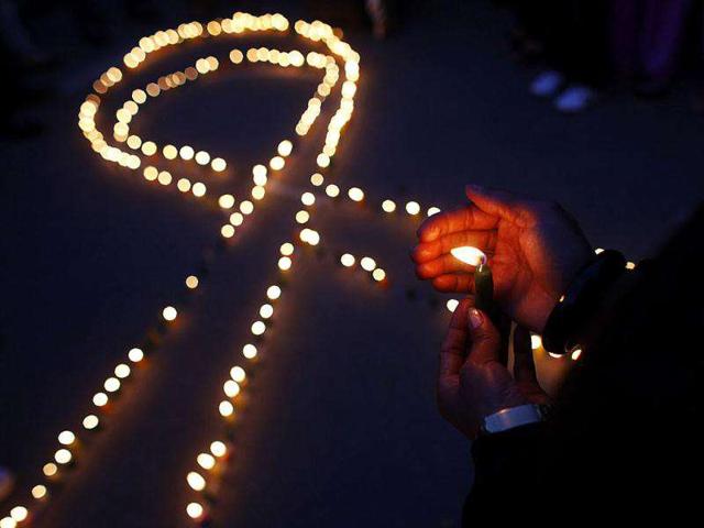 Nepalese light candles in the shape of the red ribbon, the universal symbol of awareness and support for those living with HIV, in Kathmandu.