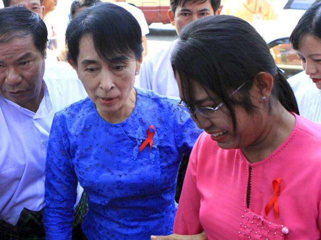 Opposition leader and Nobel peace laureate, Aung San Suu Kyi, center, and Phyu Phyu Thin, well-known AIDS activists, right, arrive at the National League for Democracy (NLD) party's headquarters to attend an event to mark World AIDS Day cerebration in Yangon, Myanmar. (AP Photo/Khin Maung Win)
