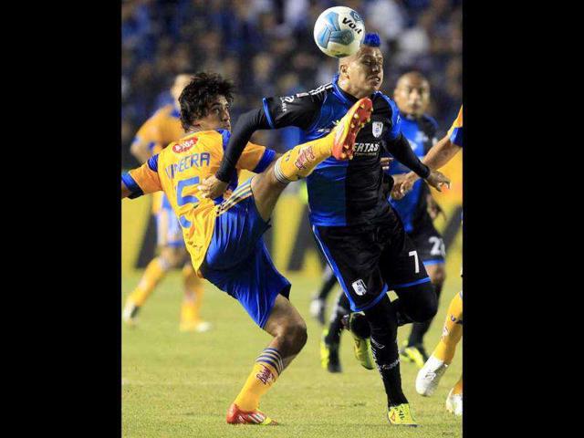 Queretaro's striker Adolfo Bautista (R) battles for the ball with Tigres' midfielder Manuel Viniegra during their Mexican league championship semi-final, first leg soccer match at Corregidora stadium in Queretaro.