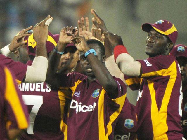 West Indies cricketer Kemar Roach (C) celebrate with teammates after taking the wicket of Indian cricketer Parthiv Patel during the second One Day International (ODI) match between India and the West Indies at The YS Rajasekhara Reddy cricket stadium in Visakhapatnam. (AFP Photo)