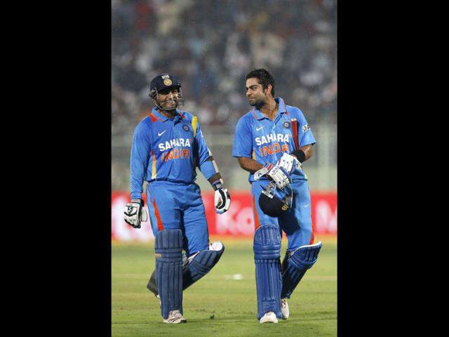 India's captain Virender Sehwag, left, and teammate Virat Kohli leave the ground after rain stopped play during their second one day international cricket match against West Indies' in Visakhapatnam. (AP Photo)