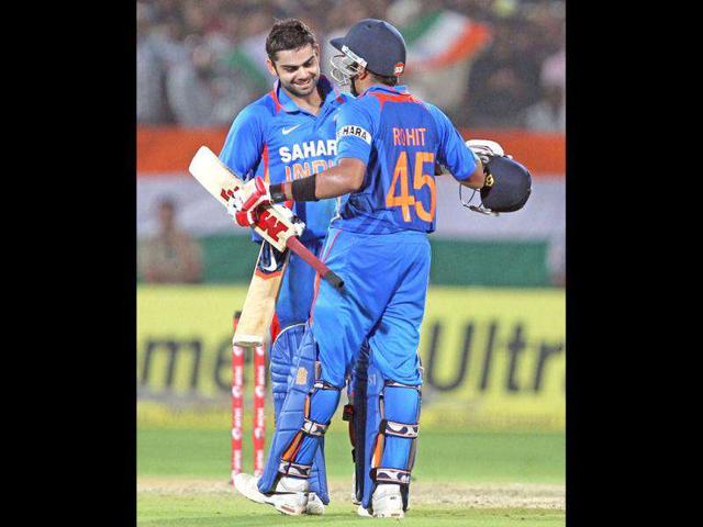 India's Rohit Sharma congratulates his teammate Virat Kohli after Kohli scored a century against West Indies during their 2nd ODI cricket match in Visakhapatnam. (PTI Photo)