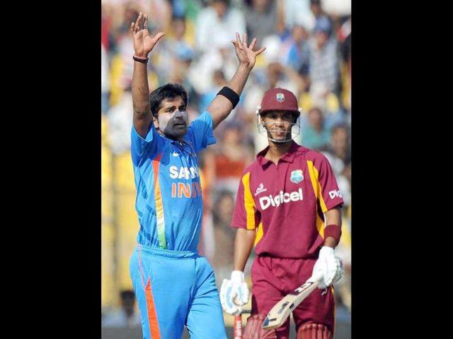 Vinay Kumar (L) celebrates the wicket of West Indies batsman Lendl Simmons (R)during the third one-day international cricket match between India and West Indies at Sardar Patel Stadium, Motera in Ahmedabad.