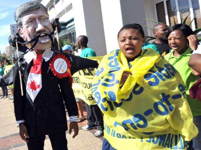 Greenpeace activists and supporters along with other non-governmental organisations protest outside the Global Business Day conference in Durban. The protest aimed at a so-called "Dirty Dozen" corporations which Greenpeace says are pulling political strings to stifle progress toward a global climate deal. (AFP/Alexander Joe)
