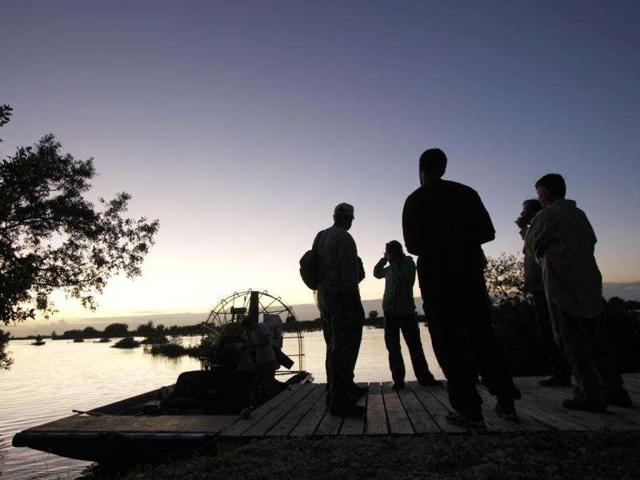 Wildlife biologists gather waiting for nightfall at a dock on a cooling canal adjacent to the Turkey Point Nuclear Power Plant during a nighttime crocodile survey in Homestead. AP Photo/Wilfredo Lee