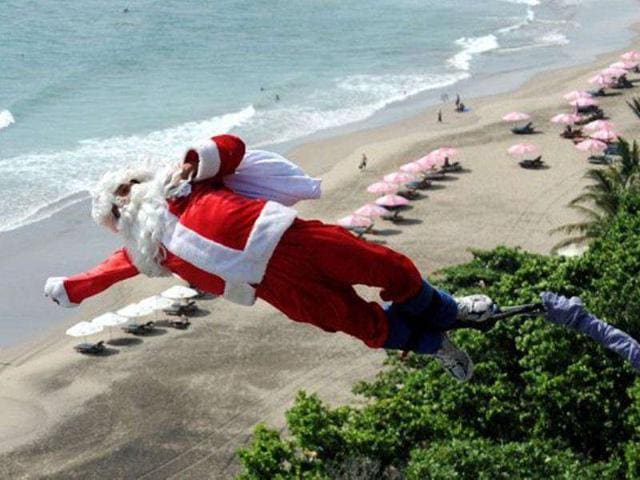 A bungee jumper dressed as Santa Claus leaps from a platform above Kuta beach, Denpasar on Indonesia's resort island of Bali.