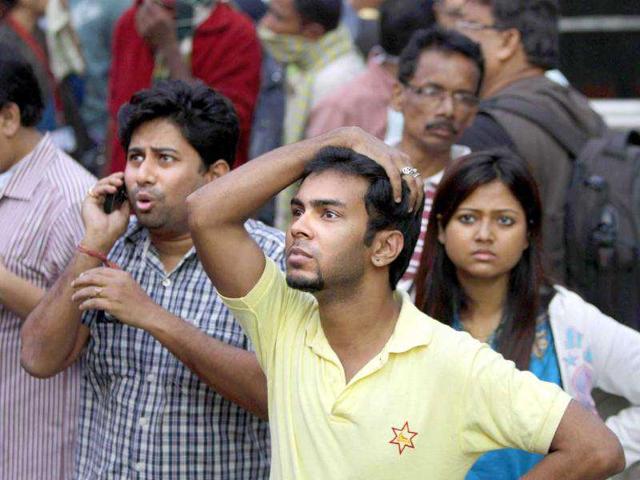 People stand outside AMRI hospital after it caught fire in Kolkata.