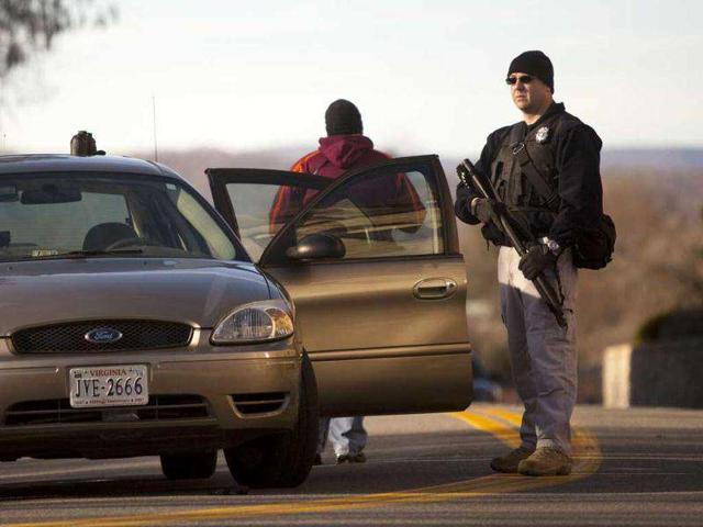 Police man a vehicle checkpoint on the campus of Virginia Tech in Blacksburg, Va. after a gunman killed a police officer in a school parking lot Thursday and was found dead. (AP Photo/The Roanoke Times, Sam Dean)