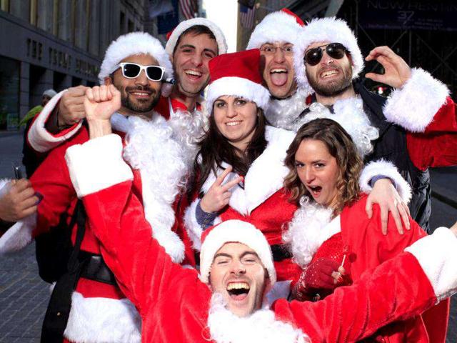 Participants of SantaCon pose for a portrait at the corner of Broad and Wall Street in New York. SantaCon is an annual celebration of the holiday season with revelers travelling around New York to different bars and locations. REUTERS/Carlo Allegri