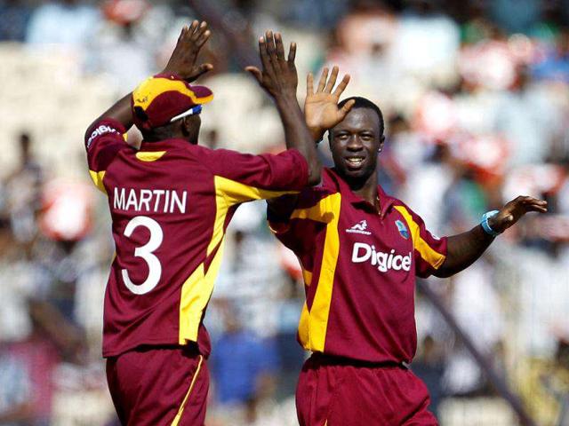 West Indies' bowler Kemar Roach (R), celebrates with teammate Anthony Martin the dismissal of India's batsman Ajinkya Rahane during their fifth one-day international cricket match in Chennai (AP Photo/Aijaz Rahi)