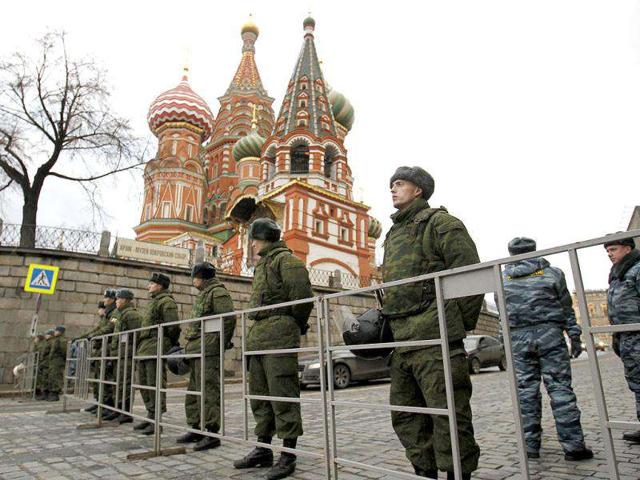 Russian police officers stand in front of St. Basil's cathedral as part of heightened security measures in central Moscow. On Saturday tens of thousands gathered across Russia to express anger at the the result of recent parliamentary elections, the largest such mass opposition gathering since the end of the Soviet Union.
