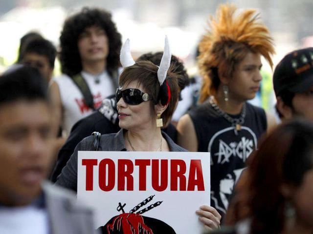 A woman wearing fake horns holds a banner during a demonstration against bullfighting in Mexico City. More than hundred demonstrators took part in a protest against bullfighting in the country. The banner reads "Torture". (Reuters)