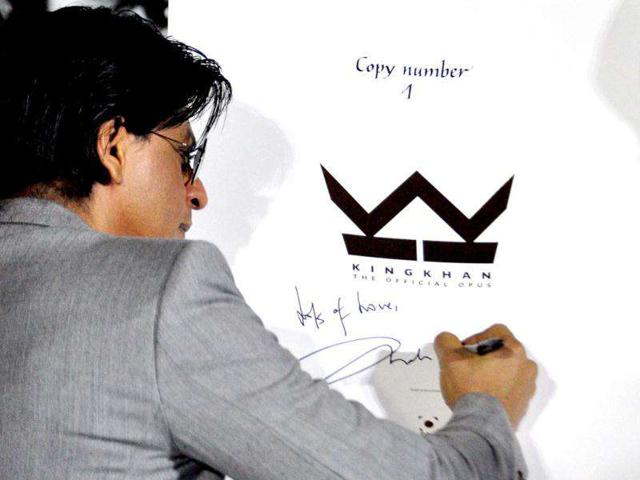 Shah Rukh signs a copy of The Official Opus of Shah Rukh Khan.