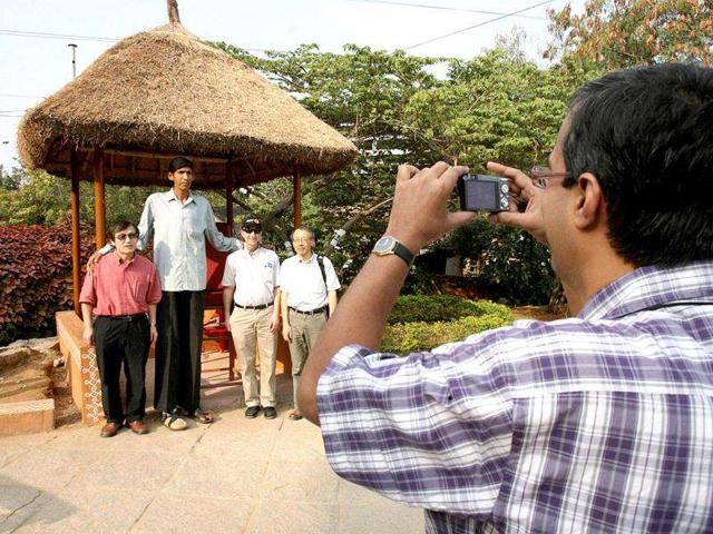 Polipaka Gattaiah, who stands at seven-and-a-half feet and claims to be the tallest man in the country, poses with foreign tourists in Hyderabad. Reuters Photo