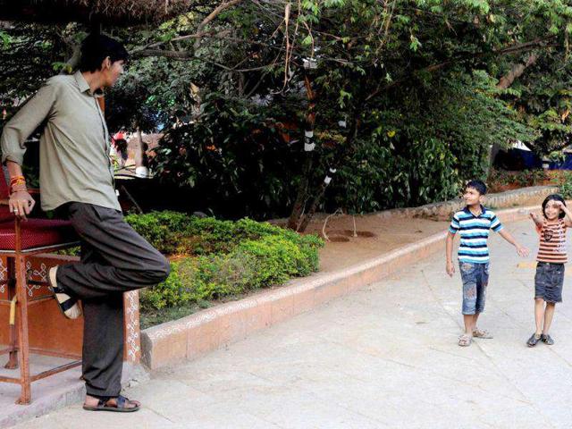 Children react as they look at Polipaka Gattaiah, who stands at seven-and-a-half feet and claims to be the tallest man in India, in Hyderabad. Reuters Photo