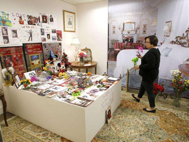 Michael Jackson fan walks to lay flowers where the headboard of the bed Jackson died. (AFP PHOTO / Frederic J. Brown)