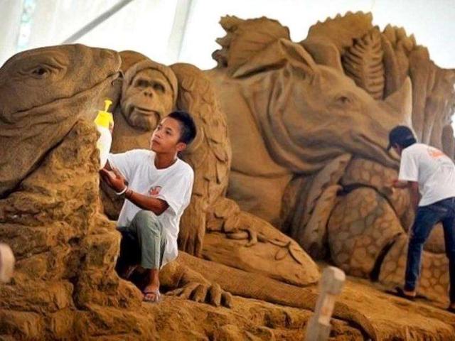 Workers spray water and clean the sand sculptures featuring world famous figures and landmarks during the 1st Sand Sculptures Festival at cultural park in Sentul outside of Jakarta, Indonesia. International artists from 11 countries created 40 large sand sculpture pieces of figures and land marks for the first Sand Sculptures Festival. (AFP/Bay Ismoyo)