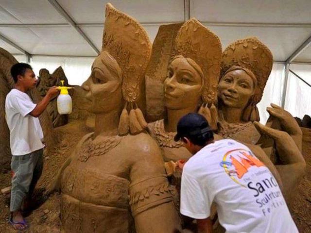 Workers spray water and clean the sand sculptures featuring world famous figures and landmarks during the 1st Sand Sculptures Festival at cultural park in Sentul outside of Jakarta, Indonesia. International artists from 11 countries created 40 large sand sculpture pieces of figures and land marks for the first Sand Sculptures Festival. (AFP/Bay Ismoyo)