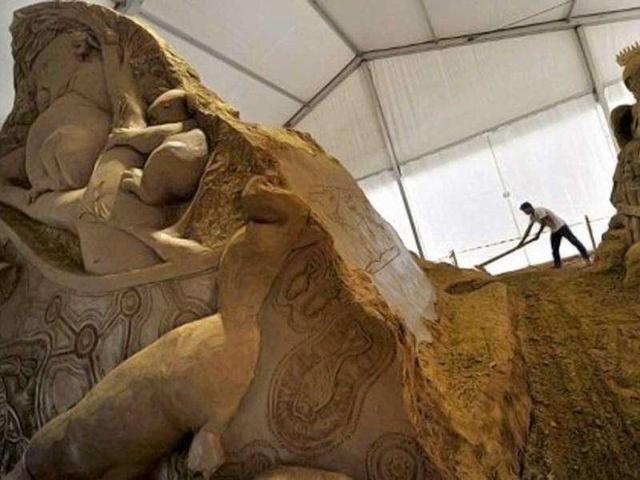 A worker cleans the sand sculptures featuring world famous figures and landmarks during the 1st Sand Sculptures Festival at cultural park in Sentul outside of Jakarta, Indonesia. International artists from 11 countries created 40 large sand sculpture pieces of figures and land marks for the first Sand Sculptures Festival. (AFP/Bay Ismoyo)