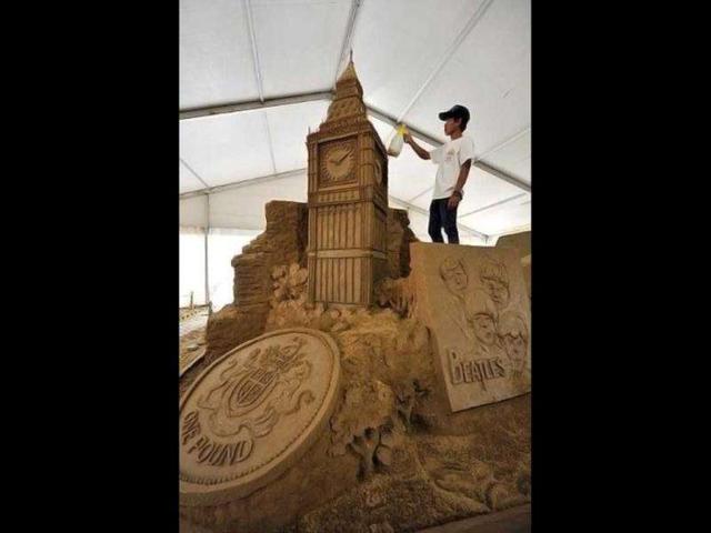 A worker sprays water on sand sculptures featuring world famous landmarks during the 1st Sand Sculptures Festival at cultural park in Sentul outside of Jakarta, Indonesia. International artists from 11 countries created 40 large sand sculpture pieces of figures and land marks for the first Sand Sculptures Festival. (AFP/Bay Ismoyo)