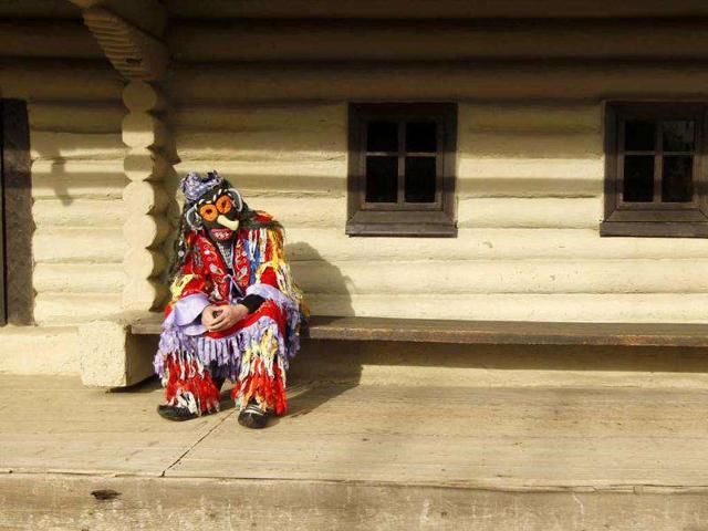 A masked man rests after performing during a traditional fair for Christmas and New Year celebrations at the Village Museum in Bucharest. (Reuters/Bogdan Cristel)