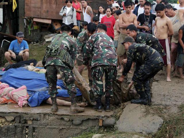Filipino soldiers line up corpses of victims of the tropical storm Washi at a village in Iligan City, on the southern island of Mindanao.