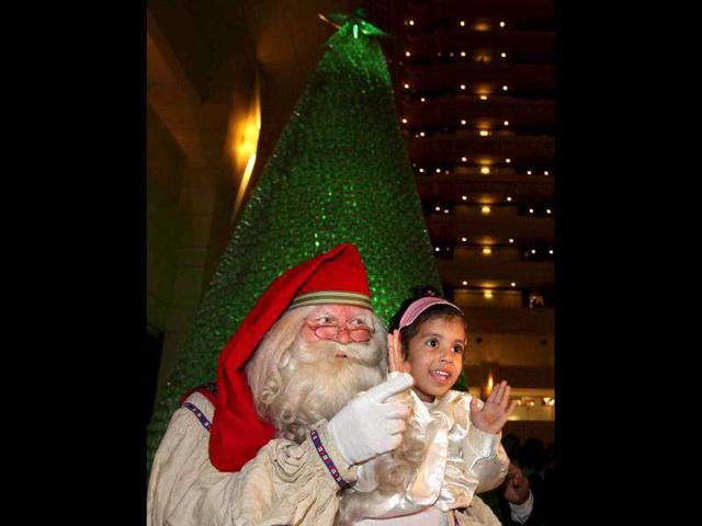Finnish Santa Claus entertains a child during the Christmas festivities in New Delhi. (PTI Photo/Vijay Verma)