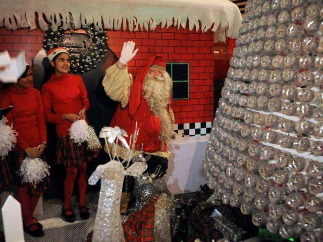 Santa Claus, who travelled to India from Finnish Lapland, waves to well-wishers during pre-Christmas celebrations at a hotel in New Delhi. (AFP Photo/Prakash Singh)
