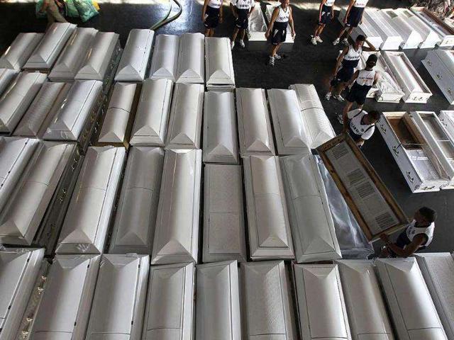 Philippine Navy soldiers load coffins, to be transported to Cagayan De Oro city, onto a navy ship which docked in Manila. Disaster agencies on Monday delivered body bags, food, water, and medicine to crowded evacuation centres in the southern Philippines as officials ordered the digging of graves to prevent disease after hundreds died from flash floods.