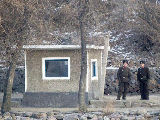 North Korean soldiers look as they stand guard along the river bank of the North Korean town of Sinuiju, opposite side to the Chinese border city of Dandong.