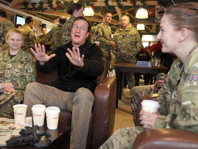 British Prime Minister David Cameron (C) gestures as he talks with British soldiers in the NAFI at Kandahar airfield in Kandahar. Cameron paid a pre-Christmas visit to British troops in Afghanistan. AFP/Pool/Jeff J Mitchell
