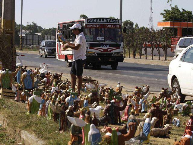 A man looks at a figure from a nativity scene sale on a street ahead of Christmas in Remanzo near Asuncion, Paraguay. (Reuters)