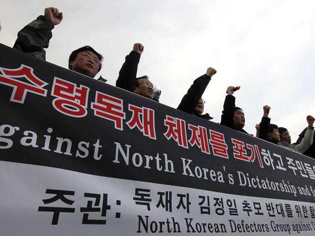 North Korean defectors who live in South Korea shout slogans and hold a banner before releasing balloons carrying anti-North Korea leaflets at the Imjinkak pavilion, near the demilitarized zone which separates the two Koreas in Paju, about 50 km north of Seoul. The defector groups who released 200,000 anti-North Korea leaflets, celebrated the death of North Korean leader Kim Jong-il and protested against condolences to the dictator's death. Reuters/Kim Kyung-Hoon