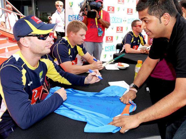 Australian cricket captain Michael Clarke (L) signs autographs for fans as members of the Indian and Australian teams meet the public at an event in Melbourne. AFP Photo/William West