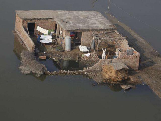 A man raises his arms towards an aid helicopter flying past his flooded house in the Sanghar district of Pakistan's Sindh province. The south eastern region of Pakistan was ravaged by floods that reportedly left over 200 people dead. Reuters