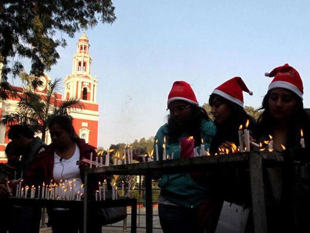People light candles at Sacred Heart Cathedral on the eve of Christmas festival in New Delhi.