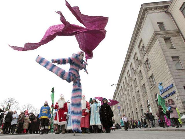 People dressed up as Father Frost, the equivalent of Santa Claus, and Snow Maiden, march as others perform in central Minsk in celebration of Christmas.